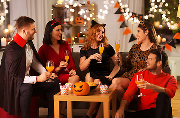 Image showing happy friends in halloween costumes at home party