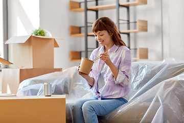 Image showing happy woman moving to new home and eating wok