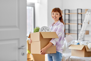 Image showing happy woman unpacking boxes and moving to new home