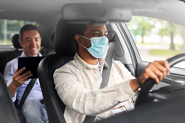 Image showing passenger with tablet pc and car driver in mask