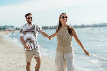 Image showing happy couple walking along summer beach