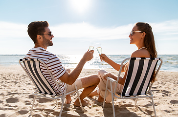 Image showing happy couple drinking champagne on summer beach