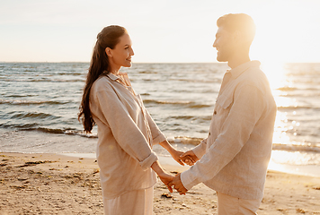 Image showing happy couple holding hands on summer beach