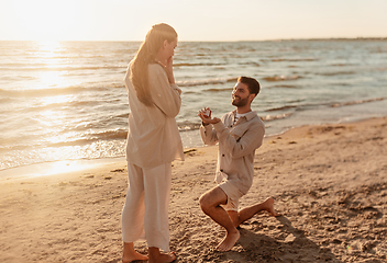 Image showing man with ring making proposal to woman on beach