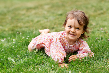 Image showing happy little baby girl lying on grass in summer