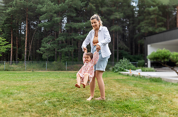 Image showing happy mother playing with baby daughter outdoors