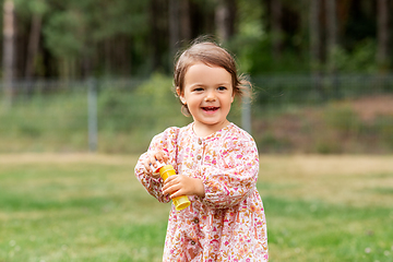 Image showing happy baby girl with soap bubble blower in summer