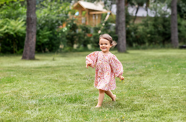 Image showing happy little baby girl running across summer field