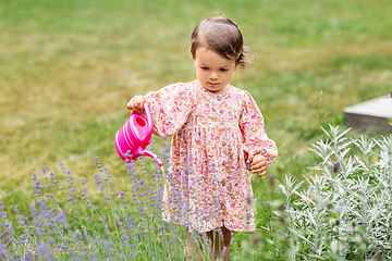 Image showing happy baby girl with watering can in summer garden