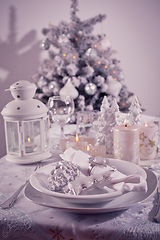 Image showing Festive  Christmas table place setting with silverware, candles and decorated Christmas tree