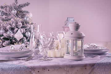 Image showing Festive  Christmas table place setting with silverware, candles and decorated Christmas tree