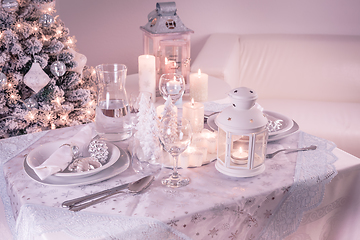 Image showing Festive  Christmas table place setting with silverware, candles and decorated Christmas tree