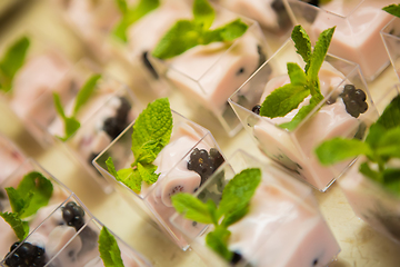 Image showing Layered dessert with fruits, nuts and cream cheese in glass jar