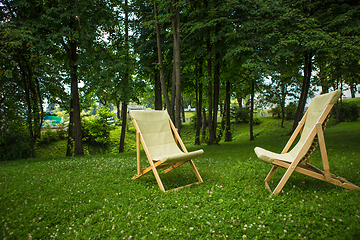 Image showing couple of chairs in park at sunset 