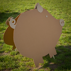 Image showing Cardboard pig on a green grass. Creative decoration.