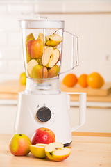 Image showing Young man cooking apple smoothie in blender