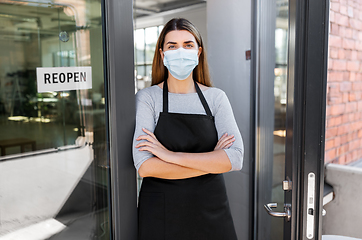 Image showing woman in mask with reopen banner on door glass