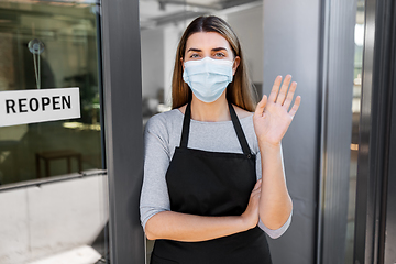 Image showing woman in mask with reopen banner on door glass