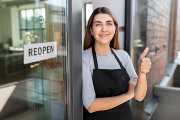 Image showing woman with reopen banner on door showing thumbs up