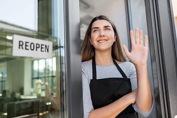 Image showing happy woman with reopen banner to door glass