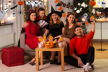 Image showing happy friends in halloween costumes taking selfie