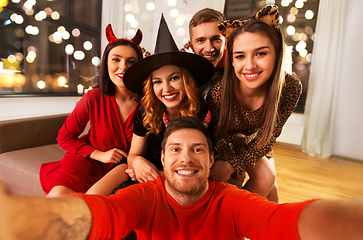 Image showing happy friends in halloween costumes taking selfie