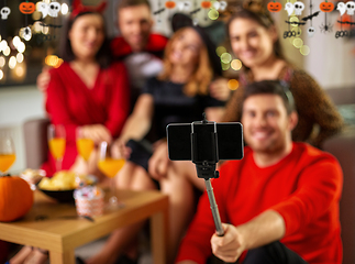 Image showing happy friends in halloween costumes taking selfie
