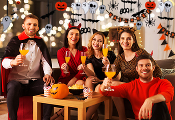 Image showing happy friends in halloween costumes at home party