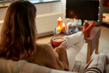 Image showing woman watches tv and drinks cocoa on halloween