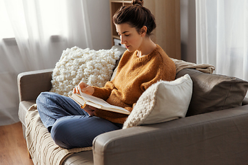 Image showing young woman reading book at home
