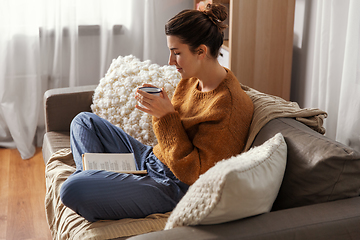 Image showing woman drinking coffee and reading book at home