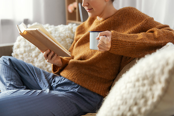 Image showing woman drinking coffee and reading book at home