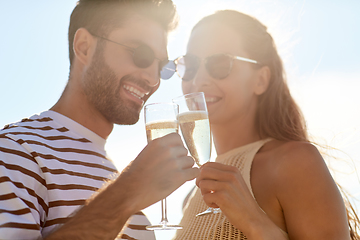 Image showing happy couple drinking champagne on summer beach