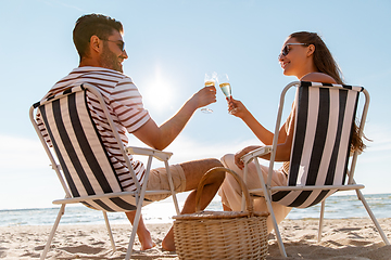 Image showing happy couple drinking champagne on summer beach