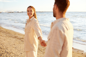 Image showing happy couple holding hands on summer beach