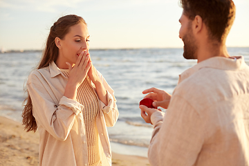 Image showing man with ring making proposal to woman on beach