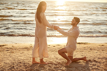 Image showing man with ring making proposal to woman on beach