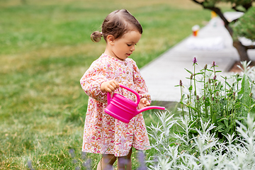 Image showing happy baby girl with watering can in summer garden