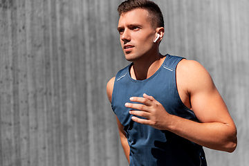 Image showing young man in earphones outdoors