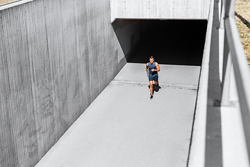 Image showing young man running out of tunnel