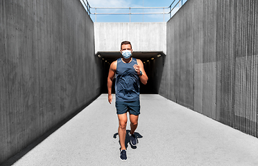 Image showing young man in medical mask running outdoors