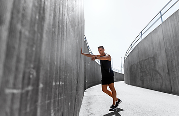 Image showing young man with fitness tracker on city street