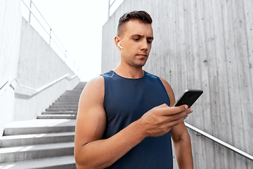 Image showing young athlete man with earphones and smartphone