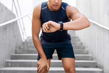 Image showing young man with fitness tracker on city street