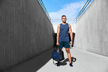 Image showing sportsman with bag and bottle walking outdoors