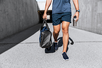 Image showing sportsman with bag and bottle walking outdoors