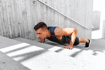 Image showing young man doing push ups on stairs outdoors