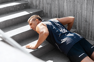 Image showing young man doing push ups on stairs outdoors