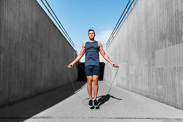 Image showing man exercising with jump-rope outdoors