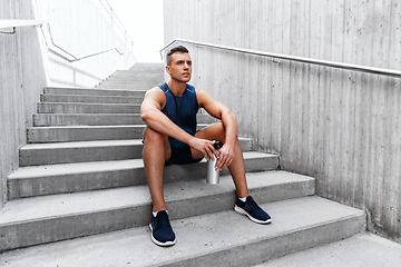 Image showing sportsman with bottle sitting on city bench